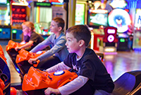 Kids on motorcycle game in arcade nearby to Seaside Park vacation rentals