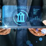 Futuristic hologram of a laptop showing a bank icon with the text "BANKING" above. The whole graphic has a blue-hue; ITM service