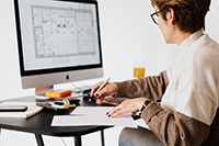 Custom home builder in NJ reviews a floorplan on a computer